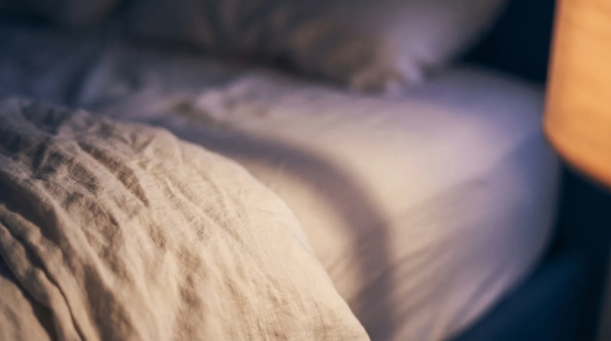 Drap de lin crème traversé par une ombre au crépuscule