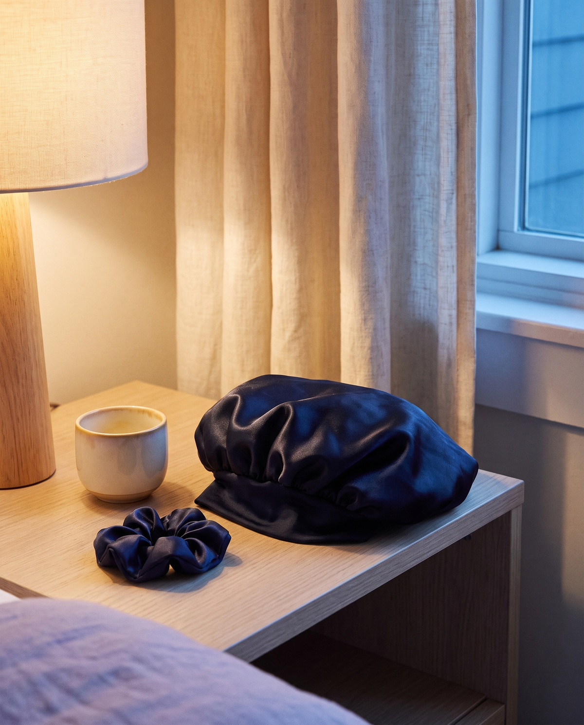 Le bonnet en satin posé sur une table de nuit à côté d'un chouchou