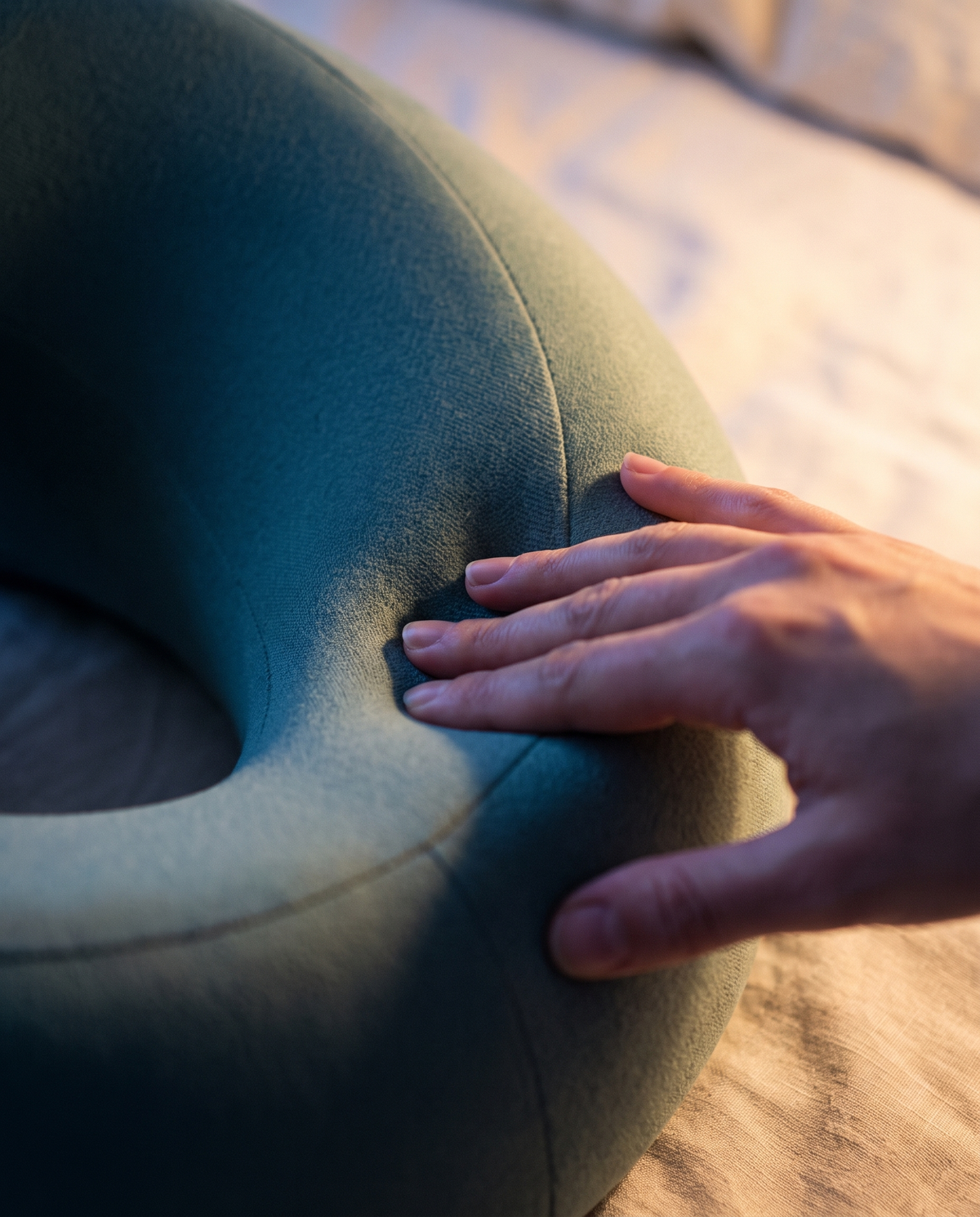 Une main presse la mousse à mémoire du coussin